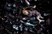 Puppe Elise liegt zwischen Bier- und Whiskeydosen. Doll Elise is leying between beer- and whiskey cans.