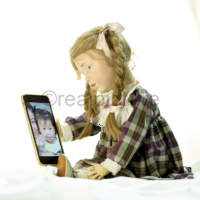 Puppe Elise mit freundlichem Smartphone. Doll Elise with a friendly smartphone.
