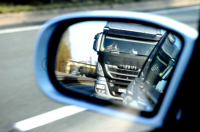 Normale Härte!? Ein LKW-Fahrer telefoniert mit seinem Handy, hält sich die Hand vor Augen  und beachtet nicht den Sicherheitsabstand.