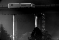 Ein LKW fährt in der frühen Morgensonne über eine Autobahnbrücke.